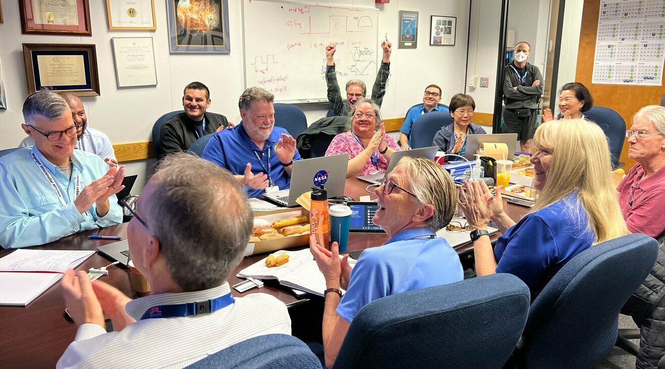 Members of the Voyager team celebrate at NASA's Jet Propulsion Laboratory after receiving data about the health and status of Voyager 1 for the first time in months.