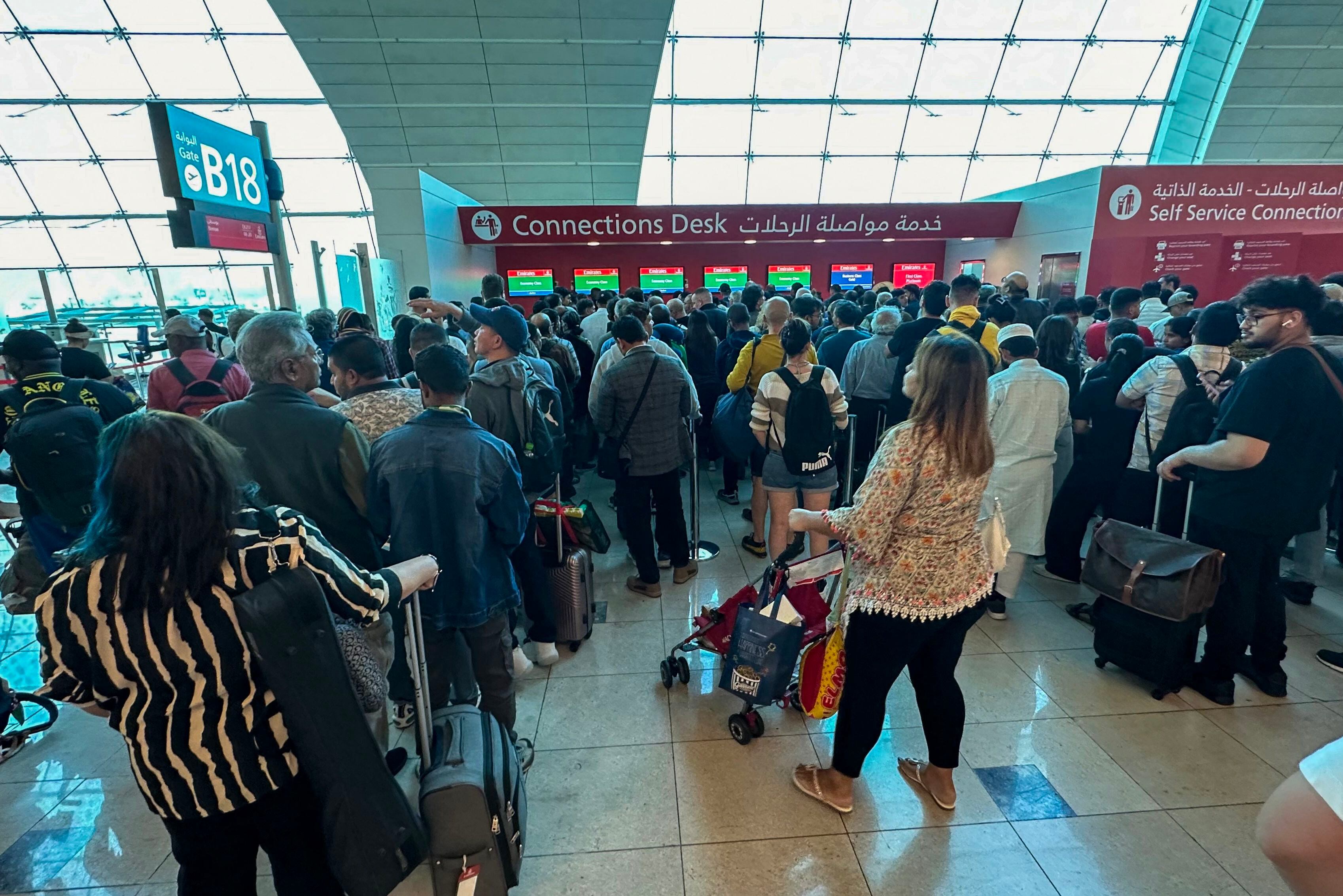 Passengers queue at a flight connection desk at the Dubai International Airport on Wednesday. Dubai's main airport diverted scores of incoming flights on Tuesday as heavy rains lashed the United Arab Emirates, causing widespread flooding around the country.