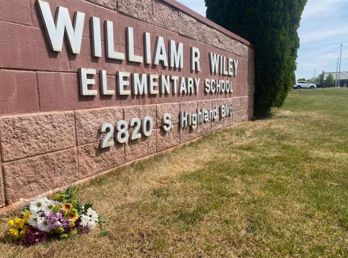 A bunch of flowers Tuesday afternoon lay near the sign for William Wiley Elementary School in West Richland. Students returned to class on Wednesday morning with therapy dogs and counselors.