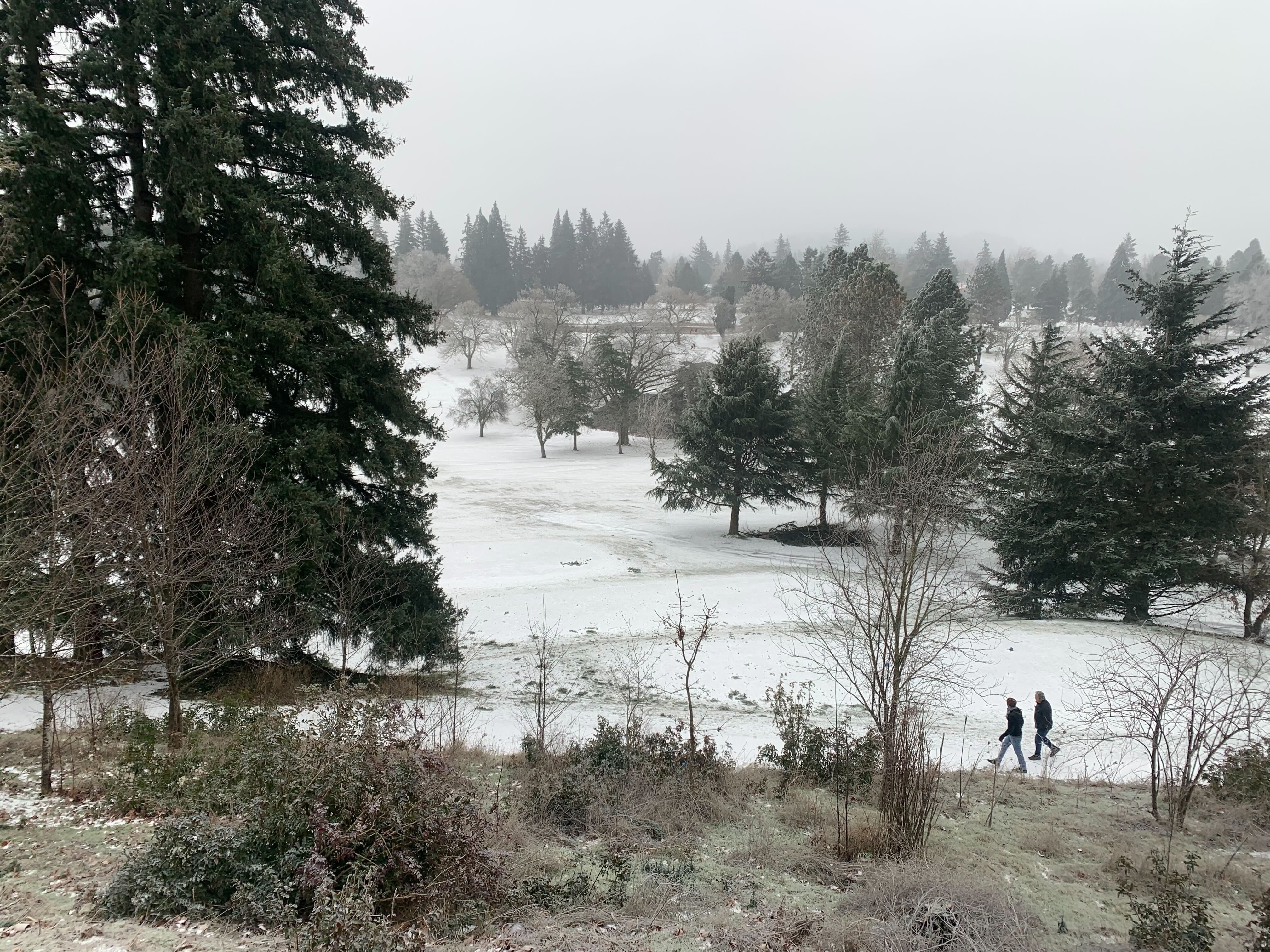 Two people take a walk through the snow at Rose City Golf Course in Portland, Oregon on Friday, Dec. 23, 2022. The city of Portland attempted to pitch the site as an alternative for an MLB ballpark.