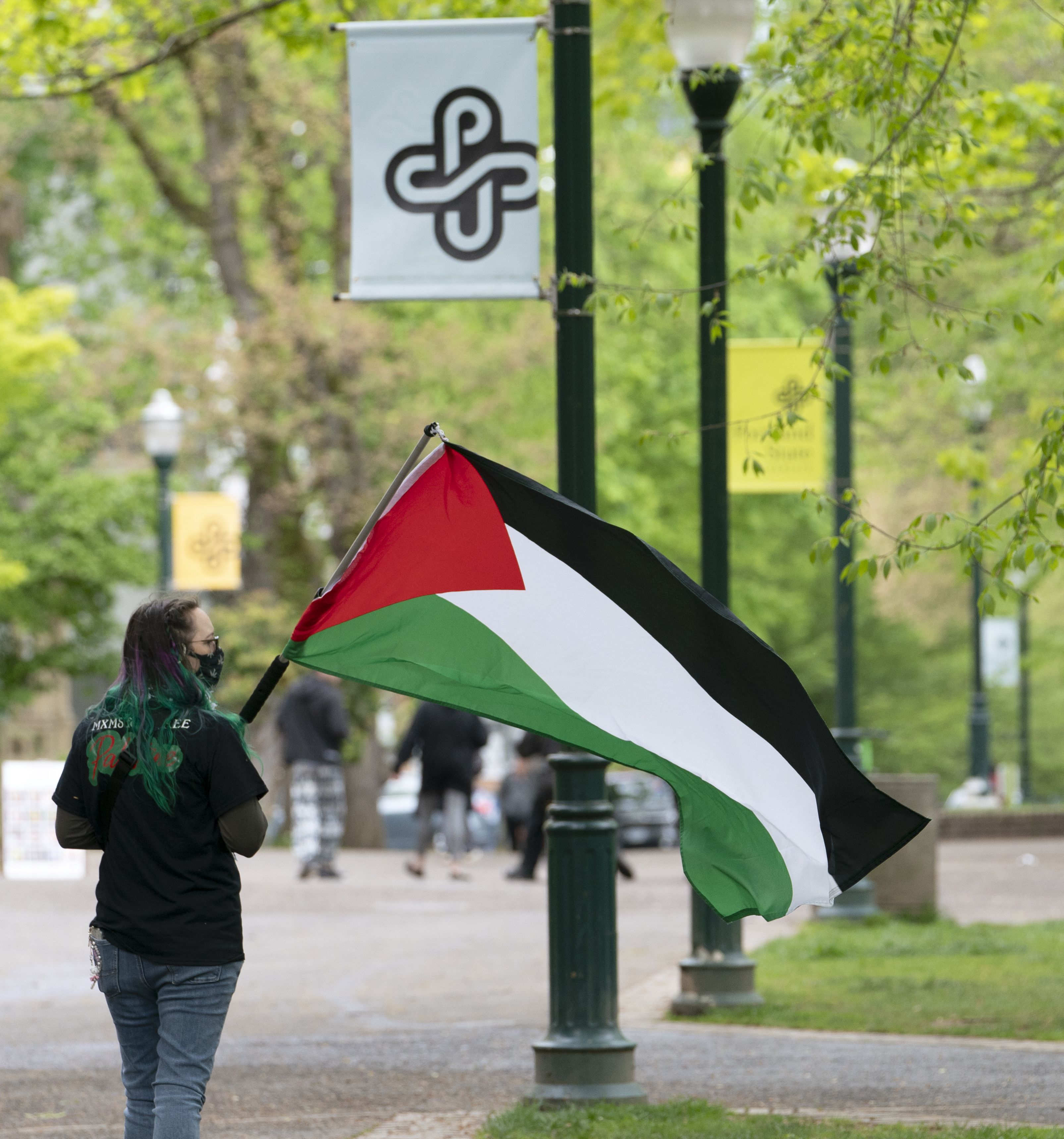 A protester carries a flag in Portland State Univeristy’s South Park Blocks, April 26, 2024. Protesters in support of Palestinians in Gaza and in protest of Portland State University’s ties with companies that have contracts with Israel, set up tents and barricades on Thursday and were removed by police after several hours. Police warned in a statement Friday morning that anybody occupying a closed park, engaging in violent activity, or destroying property could be arrested.