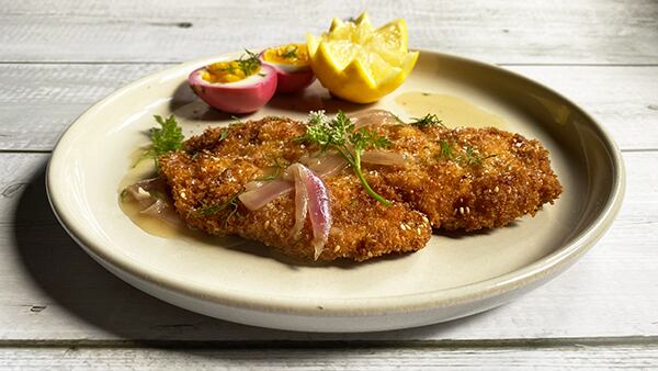 A plate of matzo-crusted chicken schnitzel with onion-cider gravy
