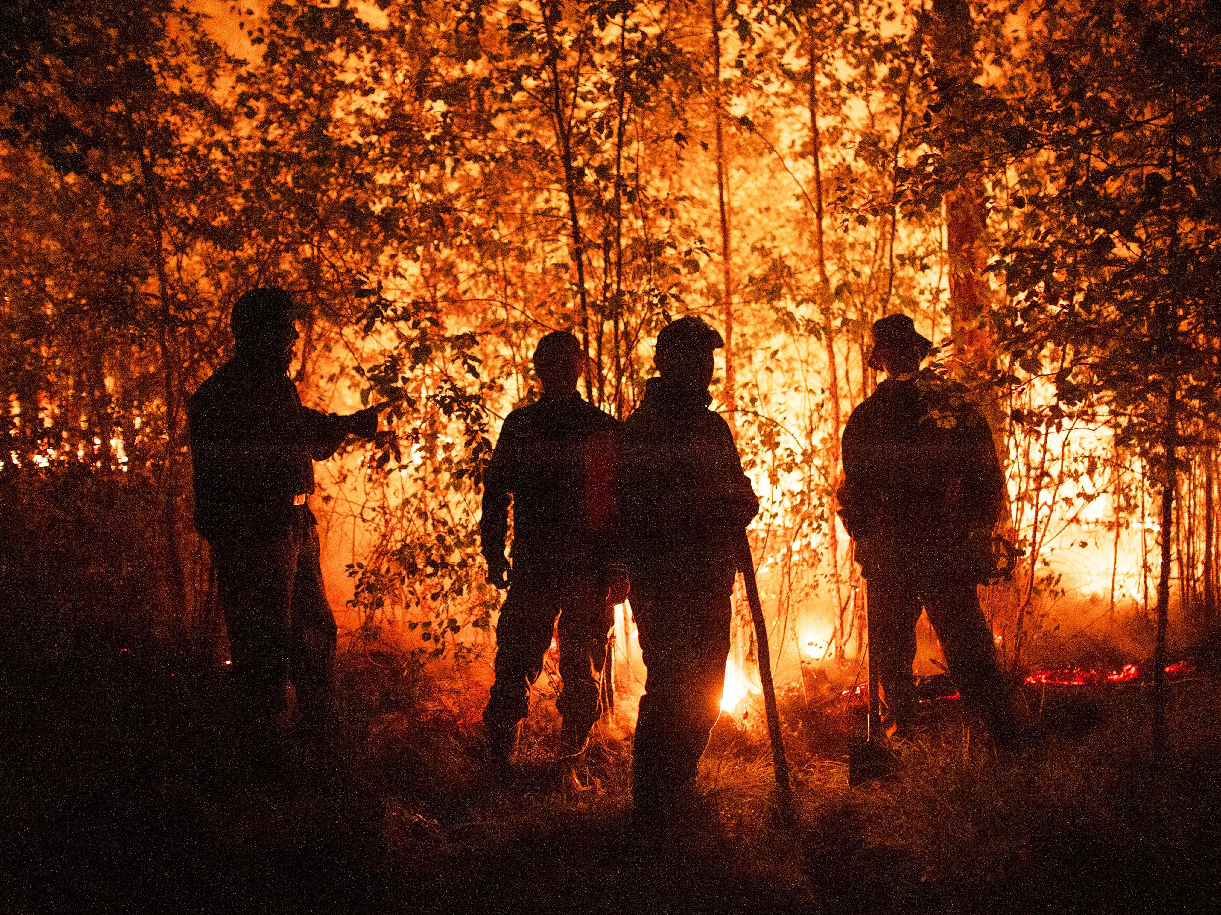 Firefighters work at the scene of forest fire near Kyuyorelyakh village west of Yakutsk, in Russia on Aug. 5, 2021.