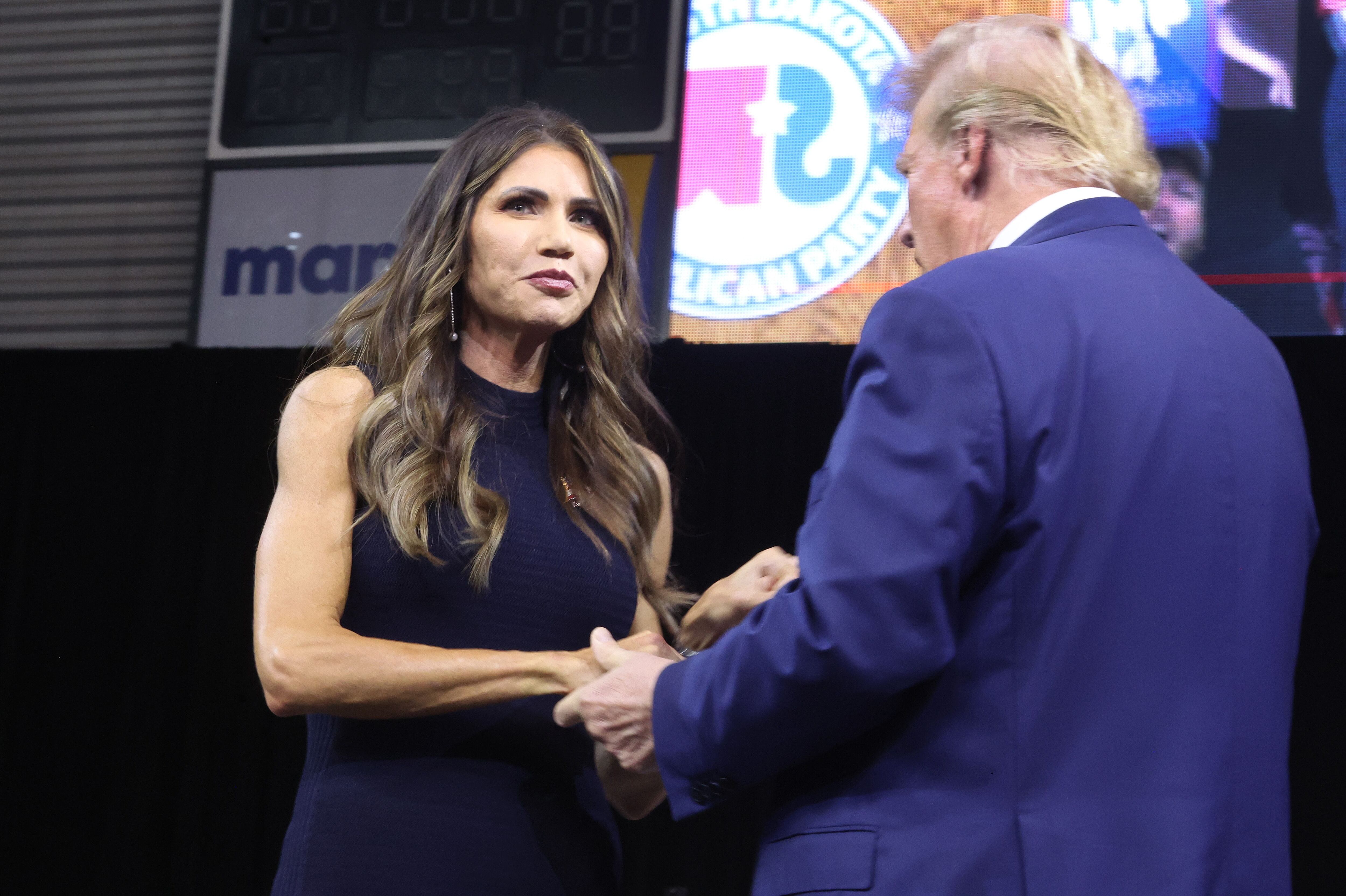 Former President Donald Trump greets South Dakota Gov. Kristi Noem at a rally hosted by the South Dakota Republican Party on Sept. 8 in Rapid City, S.D.