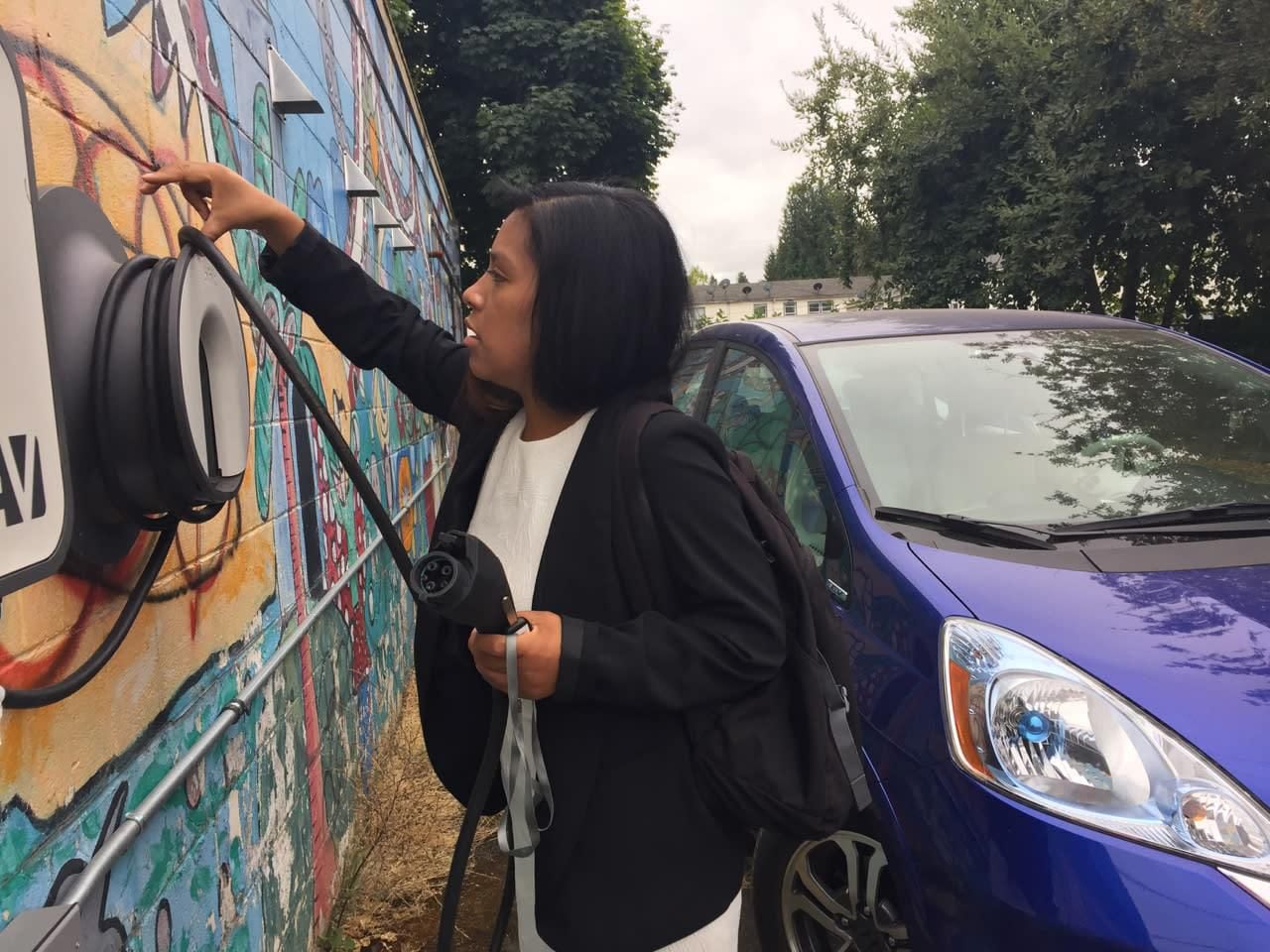 Ana Mendoza unplugs a Honda Fit EV at a low-income apartment complex in Northeast Portland's Cully neighborhood. 