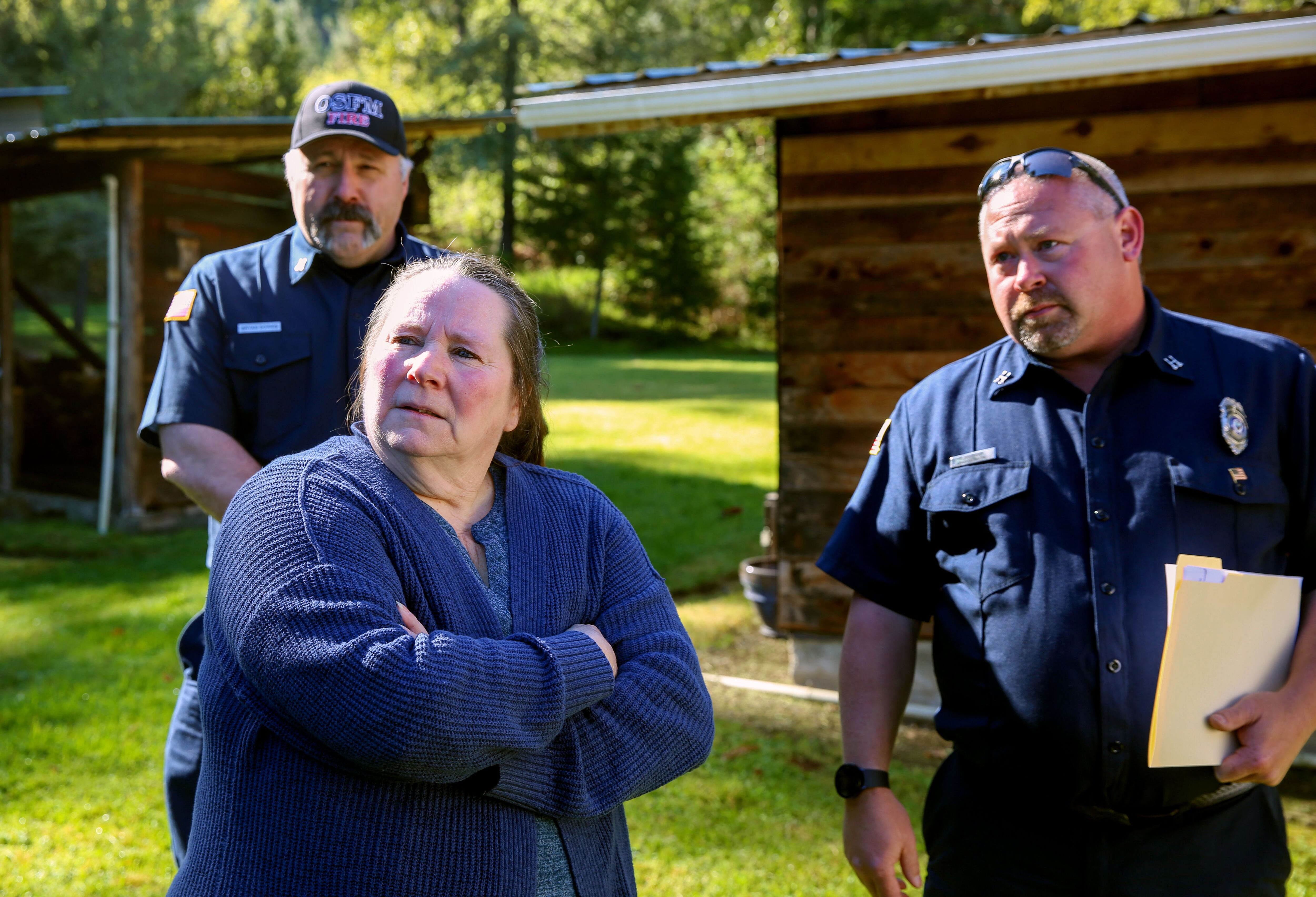 Becky Watkins worked with Deputy Fire Marshals Rich Holloway, right, and Bryan Dorris, left and behind, to improve her Days Creek, Ore., home's wildfire defenses on April 18, 2024.