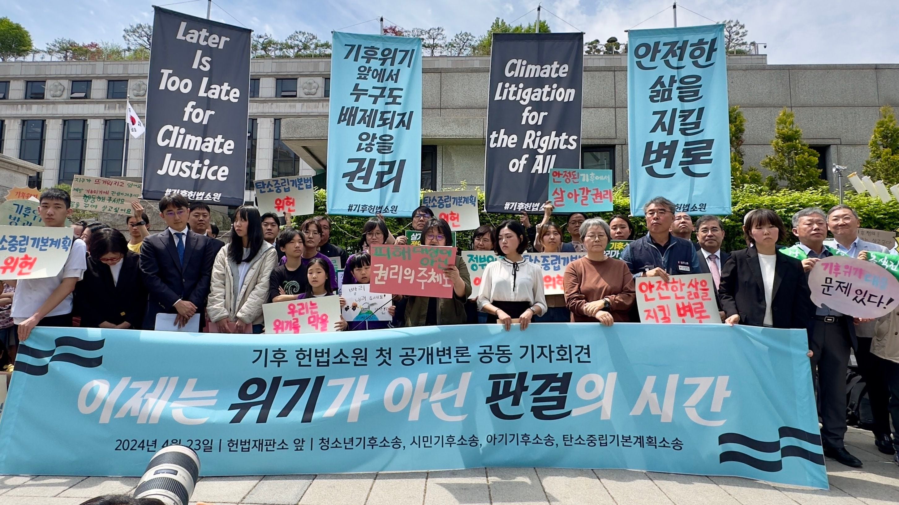Plaintiffs, lawyers and activists gather outside South Korea's constitutional court in Seoul ahead of a public hearing for a climate lawsuit on Tuesday, April 23, 2024.