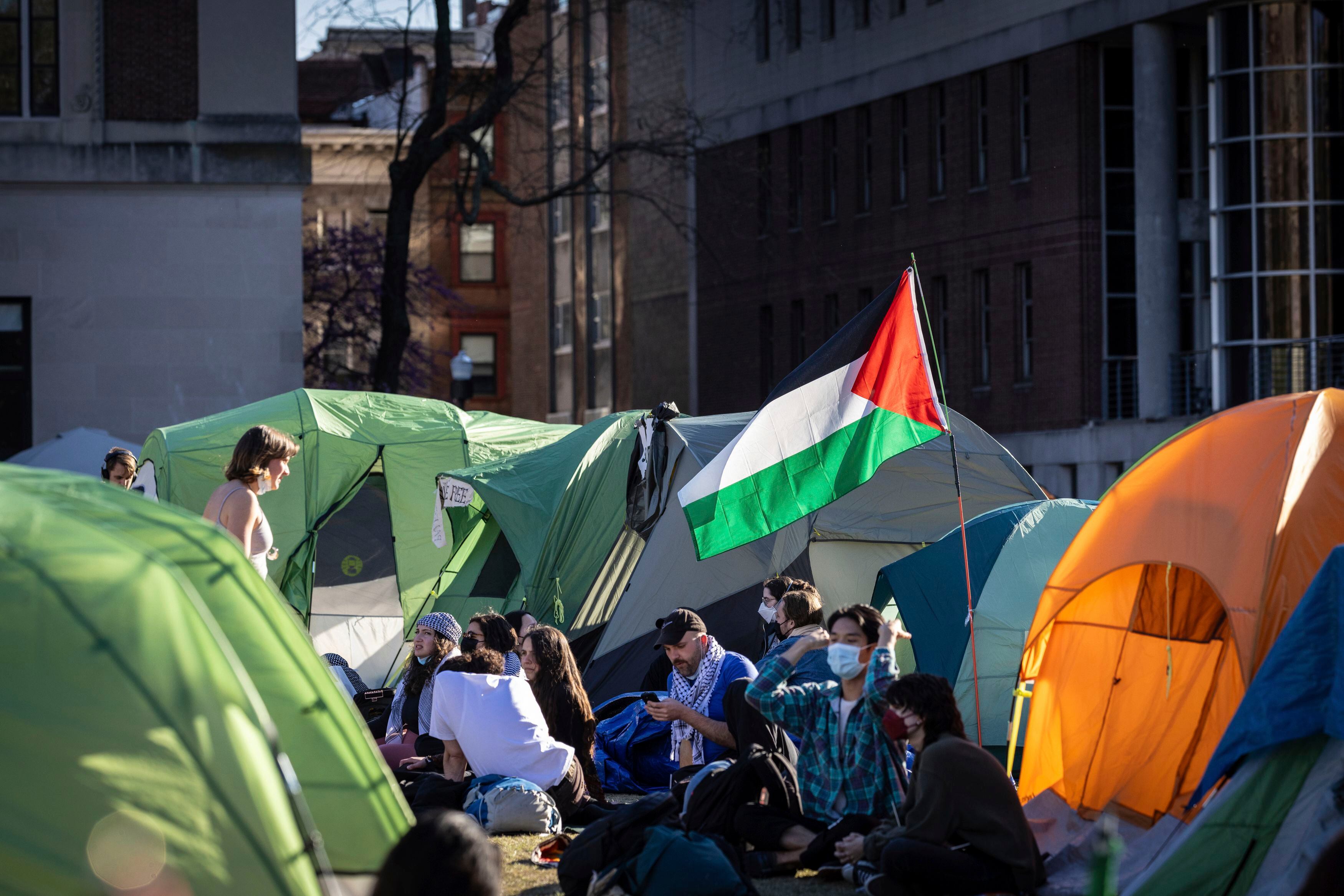 People sit outside tents at the pro-Palestinian demonstration encampment at Columbia University in New York on Wednesday April 24, 2024.